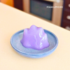 Glossy purple taro agar jelly shaped like Ditto on a ceramic dish – cute and wobbly Pokémon-inspired dessert